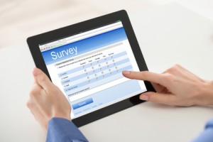Close-up Of Woman Filling Online Survey Form On Digital Tablet